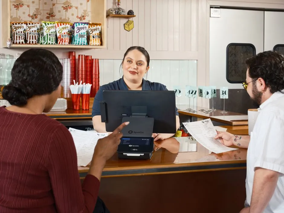 Counter-service staff taking an order at a modern fast-casual restaurant counter
